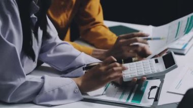 Evde hesap makinesi kullanan ve mali verileri hesaplayan genç bir iş kadını