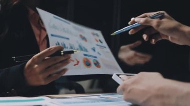 Ekonomik tablolar ve grafikler ofisteki masada tartışılıyor..