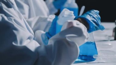 Laboratuvar asistanı şişeden su dolduruyor.