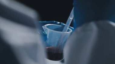 Bilim adamı sıvı bir tüp tutuyor.