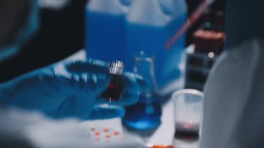 Laboratuvar asistanı test tüpünü kanla alıyor..