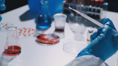 Bilim adamı sıvı ile test tüpü üzerinde çalışıyor.