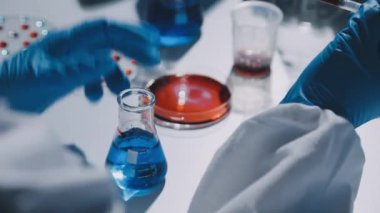 Laboratuvar bilim adamı elinde bir tüp kan tutuyor.