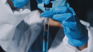 Laboratuvarda bilim adamı, bilim adamı ya da laboratuvar çalışanı ya da elinde tüp, test tüpü ya da sıvıyla sıvı tutan bilim adamı
