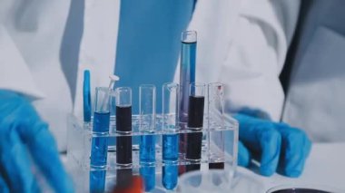 Laboratuvarda deney tüpleriyle çalışan bilim adamı.