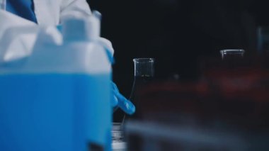 Laboratuvardaki laboratuvar asistanı. Doktor elinde sıvı olan bir tüp tutuyor..