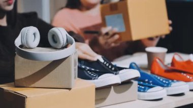 Bir çift ayakkabıdan kulaklık seçen bir kadın. Beyaz deri ayakkabılı bir kadının elini kapat..