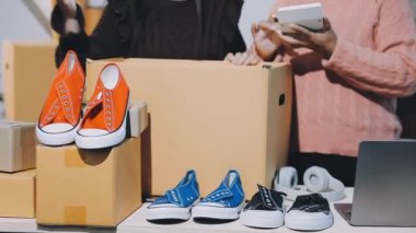 Genç Asyalı bayan arkadaşlar küçük bir dükkandan online alışveriş yapıyorlar ve bir tablet bilgisayar kullanıyorlar..