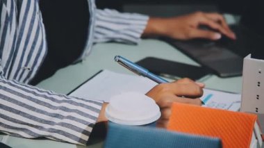 İş adamı büro masasına not defteri yazıyor..
