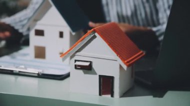 Beyaz arka planda model ve kağıt modelli adam el ele tutuşuyor.