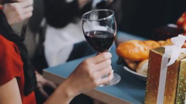 Yakın plan. Kadın eli kırmızı şarap tutuyor ve restoranda Noel 'i kutluyor. Şenlikli tatil konsepti