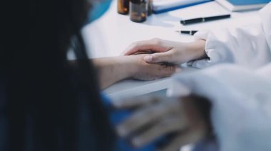 Bir hastanın elini tutan bir doktorun fotoğrafını çek.