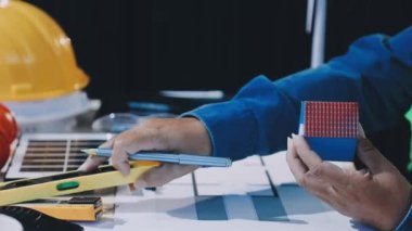 Genç mimar mühendisi modern ofiste planlar üzerinde çalışıyor.