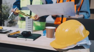 İş yerinin planıyla birlikte miğferde inşaat mühendisi..