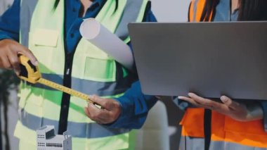 Asyalı mühendis inşaat projesinde çalışıyor.