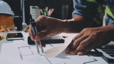 Mimar ofiste mimari planlar üzerinde çalışıyor.