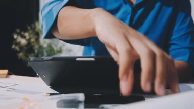 Hesap makinesi ve dizüstü bilgisayarı olan bir iş adamı.