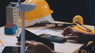 Hesap makinesi, dizüstü bilgisayar, tablet ve hesap makinesi, plan, plan ve planla birlikte inşaat masasında çalışan mühendis.