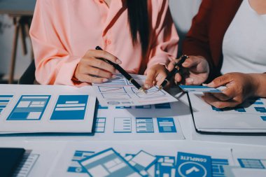 Genç Asyalı iş dünyası yaratıcı takımı mobil uygulama yazılım tasarımı projesinde birlikte çalışıyor. Beyin fırtınası toplantısı, internet teknolojisi, akıllı telefon uygulama tasarımcısı, ofis çalışanı takım çalışması konsepti