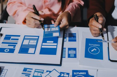 Genç Asyalı iş dünyası yaratıcı takımı mobil uygulama yazılım tasarımı projesinde birlikte çalışıyor. Beyin fırtınası toplantısı, internet teknolojisi, akıllı telefon uygulama tasarımcısı, ofis çalışanı takım çalışması konsepti