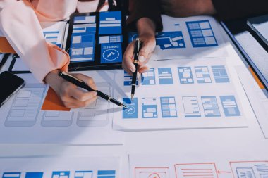 Genç Asyalı iş dünyası yaratıcı takımı mobil uygulama yazılım tasarımı projesinde birlikte çalışıyor. Beyin fırtınası toplantısı, internet teknolojisi, akıllı telefon uygulama tasarımcısı, ofis çalışanı takım çalışması konsepti