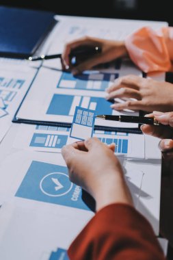 Genç Asyalı iş dünyası yaratıcı takımı mobil uygulama yazılım tasarımı projesinde birlikte çalışıyor. Beyin fırtınası toplantısı, internet teknolojisi, akıllı telefon uygulama tasarımcısı, ofis çalışanı takım çalışması konsepti