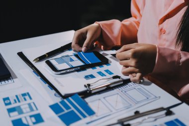 Genç Asyalı iş dünyası yaratıcı takımı mobil uygulama yazılım tasarımı projesinde birlikte çalışıyor. Beyin fırtınası toplantısı, internet teknolojisi, akıllı telefon uygulama tasarımcısı, ofis çalışanı takım çalışması konsepti