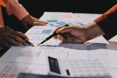 Genç Asyalı iş dünyası yaratıcı takımı mobil uygulama yazılım tasarımı projesinde birlikte çalışıyor. Beyin fırtınası toplantısı, internet teknolojisi, akıllı telefon uygulama tasarımcısı, ofis çalışanı takım çalışması konsepti