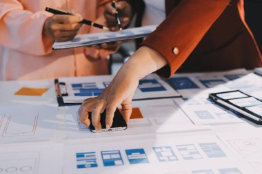 Genç Asyalı iş dünyası yaratıcı takımı mobil uygulama yazılım tasarımı projesinde birlikte çalışıyor. Beyin fırtınası toplantısı, internet teknolojisi, akıllı telefon uygulama tasarımcısı, ofis çalışanı takım çalışması konsepti