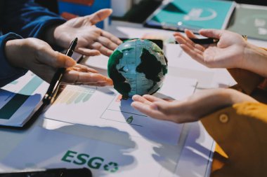 ESG 'nin çevresel sosyal yönetimi, çevre dostu şirket toplantılarında, temiz ve sürdürülebilir gelecekteki ekoloji için çevre korumasını uygulayan iş adamlarıyla dizüstü bilgisayarda sergileniyor. Önde.