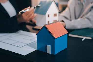 İş adamlarını ya da emlakçıları kapatın ve satış evi anlaşmasını müşterilere açıklayın. Mülkiyet, Sigorta, Komisyoncu kavramı.