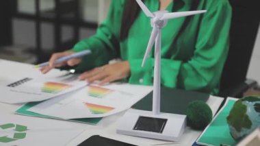 Rüzgar türbinli yeşil enerji modeli tutan kadın
