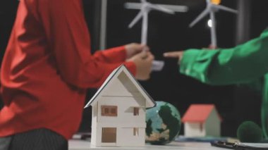 Minyatür model ve insanlar evin bir modelinin üzerinde duruyorlar..