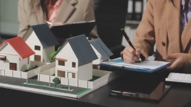 Emlakçı ev modelini ev modeli ve emlak sigortası konseptiyle tutuyor..