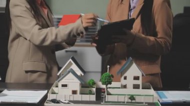 Emlakçı yeni evi modelin modeliyle tartışıyor.