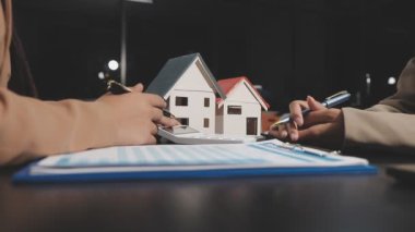 Emlakçı müşteriye anahtar veriyor.