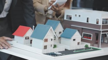 Emlakçı ev modelini gösteriyor.