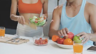 Genç adam ve kadın mutfakta meyve ve sebzelerle