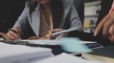 İş ekibi ofiste tartışıyor ve çalışıyor.