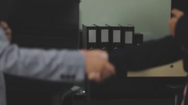 İş adamları ofiste el sıkışıyor.