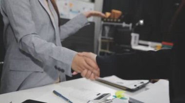 İşadamı ofiste başarılı bir iş anlaşmasıyla el sıkışıyor.