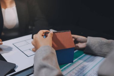 İş adamlarını ya da emlakçıları kapatın ve satış evi anlaşmasını müşterilere açıklayın. Mülkiyet, Sigorta, Komisyoncu kavramı.