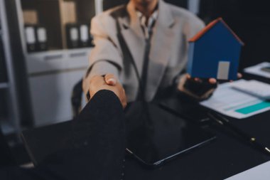 İş adamlarını ya da emlakçıları kapatın ve satış evi anlaşmasını müşterilere açıklayın. Mülkiyet, Sigorta, Komisyoncu kavramı.