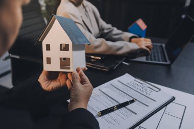 İş adamlarını ya da emlakçıları kapatın ve satış evi anlaşmasını müşterilere açıklayın. Mülkiyet, Sigorta, Komisyoncu kavramı.
