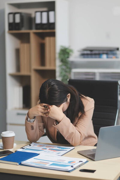 Портрет уставшей молодой бизнес-азиатки работает с документами налогообложения ноутбука в офисе. Грустный, несчастный, обеспокоенный, депрессия, или работник жизнь стресс концепции