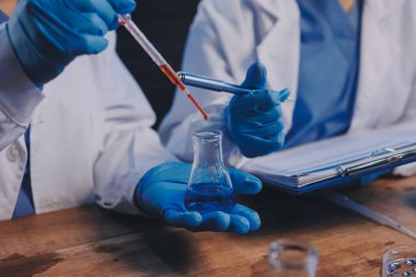 Laboratuvarda kan testi. Dispanser ile çalışan laboratuvar asistanı. Kanlı vakum tüpleri..