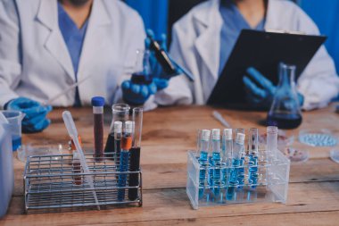 Laboratuvarda kan testi. Dispanser ile çalışan laboratuvar asistanı. Kanlı vakum tüpleri..