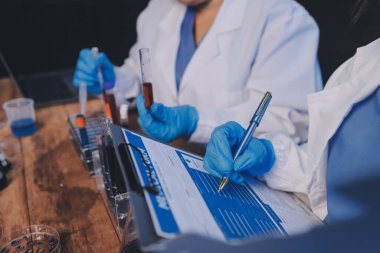 Laboratuvarda kan testi. Dispanser ile çalışan laboratuvar asistanı. Kanlı vakum tüpleri..