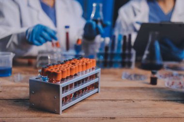 Laboratuvarda kan testi. Dispanser ile çalışan laboratuvar asistanı. Kanlı vakum tüpleri..