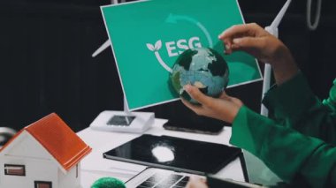 Beyaz tişörtlü, siyah ceketli, yeşil küresi ve cam küresi olan genç adam.